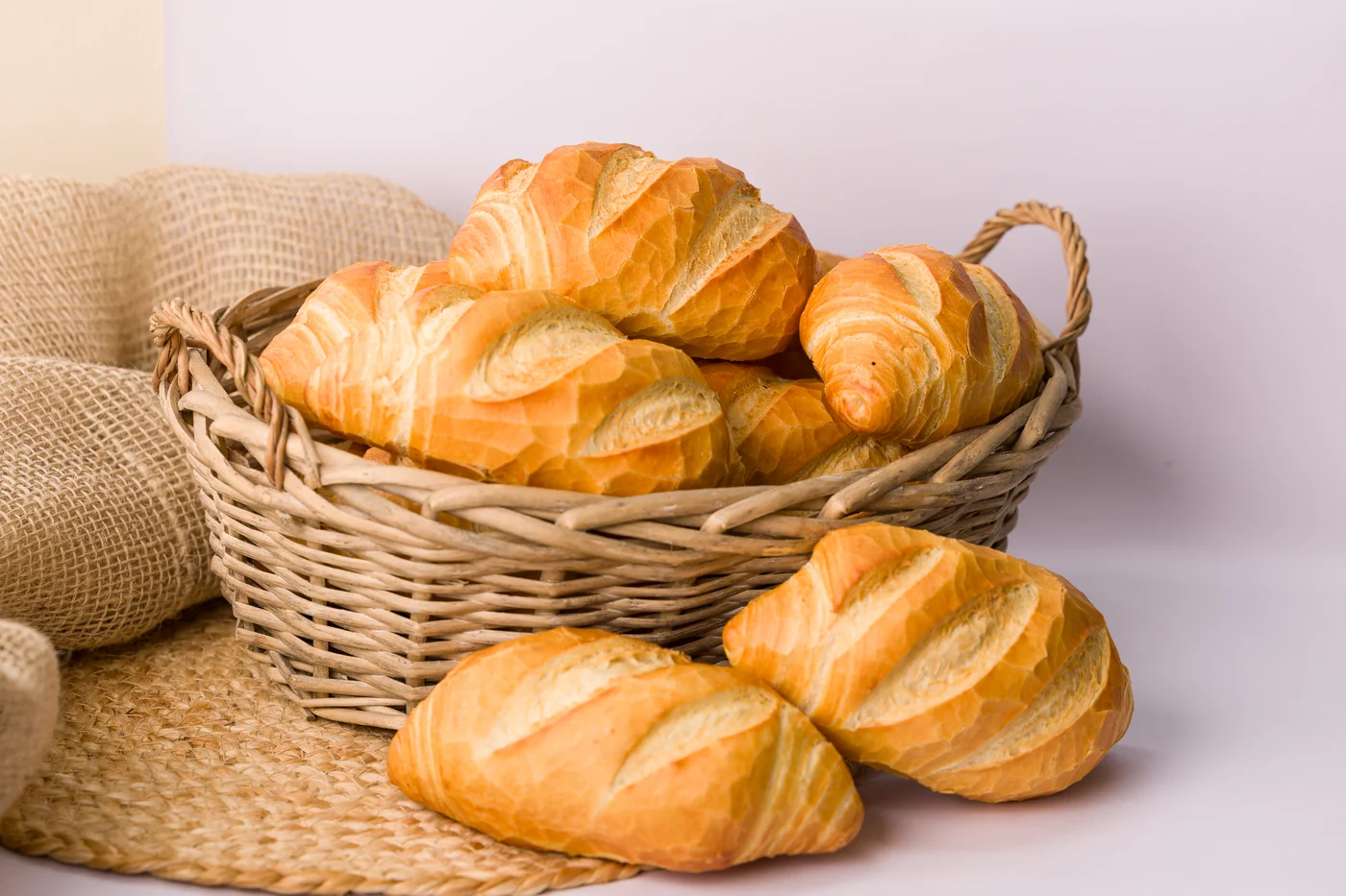 Cesta de pães sobre tecido de linho
